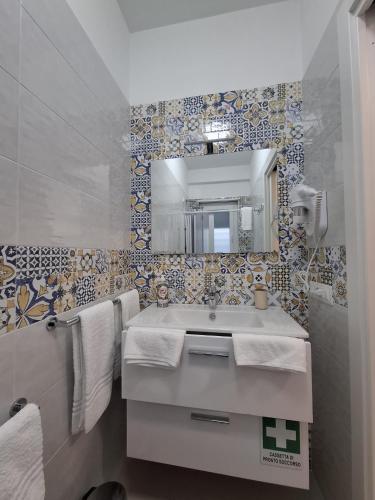 a bathroom with a sink and a mirror at Le Casette Del Mare in Crotone