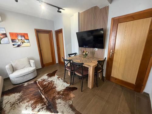 a living room with a table with chairs and a tv at Sunny hill Apartment in Golem