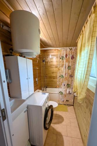a small bathroom with a washing machine in it at Private Wood Cabin in Palanga