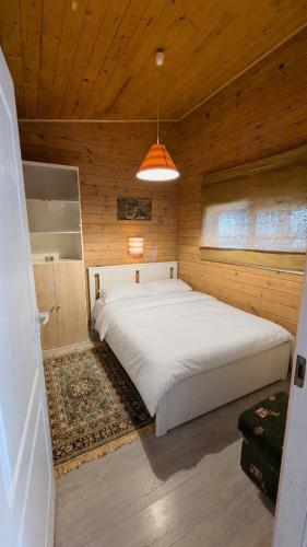 a bedroom with a large bed in a wooden room at Private Wood Cabin in Palanga