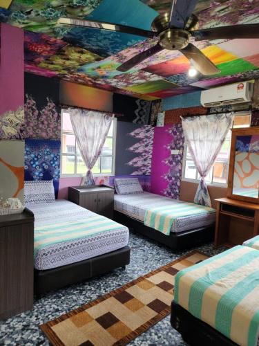 a bedroom with two beds in a room with a ceiling at CBR Beach in Kota Belud