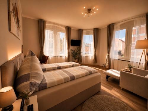 a living room with a large bed and windows at Pension J&M in Meißen