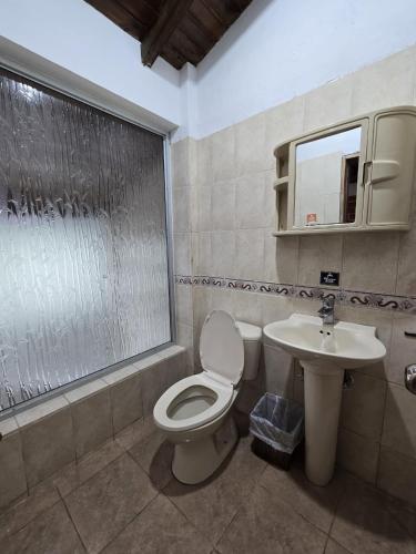 a bathroom with a toilet and a sink at Hostería Agoyán Deluxe in Ulba