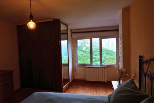 a bedroom with a bed and a large window at El Cimblu in Gradura