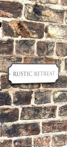 a brick wall with a rustic retreat sign on it at Rustic Retreat cottage in Thirsk
