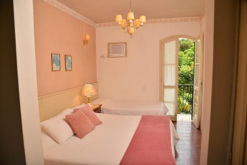 a bedroom with two beds and a window at Hotel fazenda do Cedro in Areal