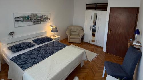 a bedroom with a bed and a chair at MAG Apartmani in Jezera