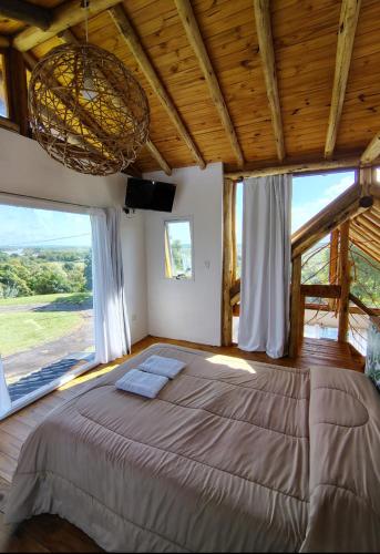 a bedroom with a large bed with large windows at Mirador in San Pedro