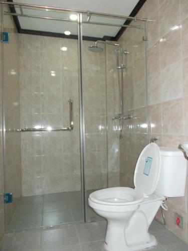 a bathroom with a toilet and a glass shower at Memory Hotel in Vientiane