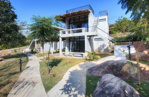 a white house with a staircase leading up to it at Twelve Oclock Resort in Si Khio