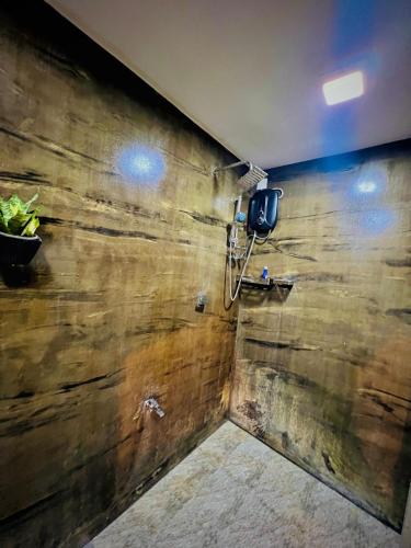 a bathroom with a wooden wall with a phone on it at LEAFORA Cottage in Galle