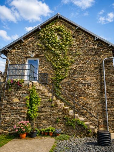 a brick building with stairs and ivy at Le Logis du Commis in Notre-Dame-dʼElle