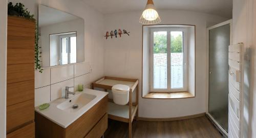 a bathroom with a sink and a toilet and a window at Le Logis du Commis in Notre-Dame-dʼElle