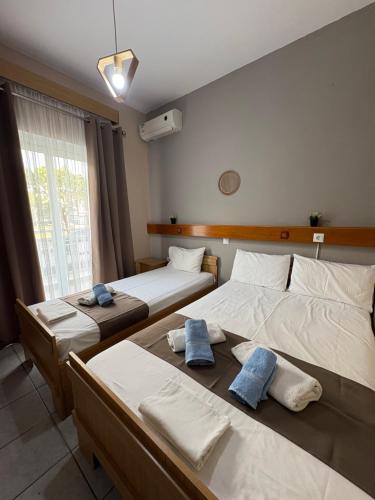 a bedroom with two beds with towels on them at Amelies Apartments in Paralia Katerinis