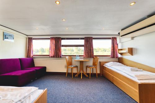 a bedroom with a bed and a table and chairs at Schiffshotel Böttger in Dresden