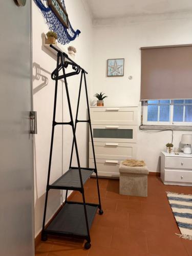 a black shelf in a room with a kitchen at Fonte da Telha Beach Hostel in Costa da Caparica