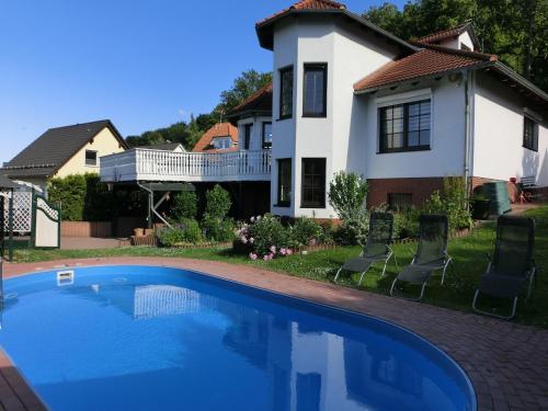 a house with a swimming pool in front of a house at Gruppenunterkunft mit Pool in Ballenstedt in Ballenstedt