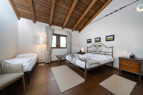 a bedroom with two beds and a table and a couch at Bastianich Rooms in Gagliano