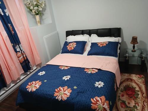 a bedroom with a bed with a blue comforter and pillows at Dreamdoor Apartments in Moncton