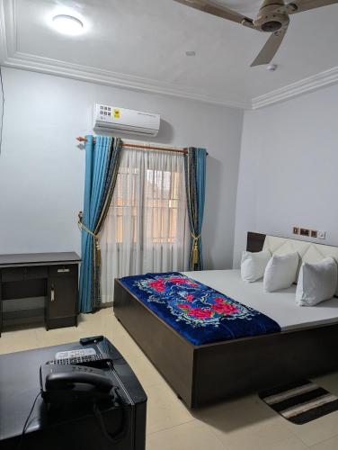 a bedroom with a bed and a television in it at WAB STAR Lodge in Kumasi