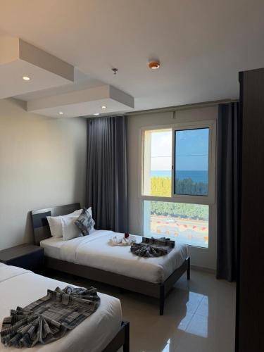 a hotel room with two beds and a window at نايس فيو بانوراما للشقق الفندقية in Al Jubail