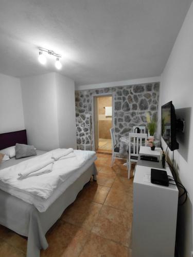 a bedroom with a bed and a tv and a table at Anastasija & Tara in Ðuraševići