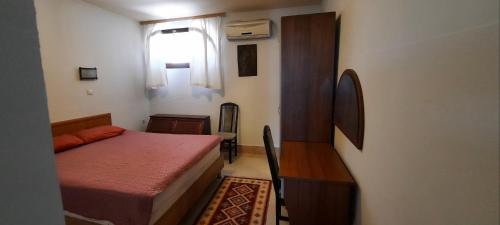 a small bedroom with a bed and a window at Cozopol Budjaka in Sozopol