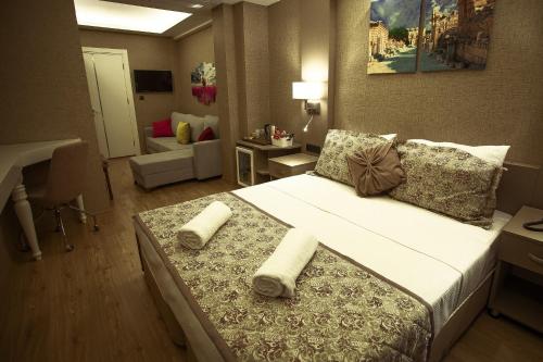a bedroom with a large bed with towels on it at Hotel Iz in Izmir