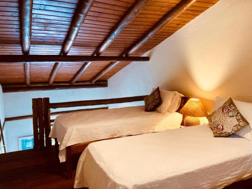 a bedroom with two beds and a window at Flats Bon Voyage Caboré - Chez Cira in Paraty