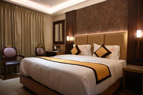 a hotel room with a large bed and a mirror at Florys Residency in Ooty