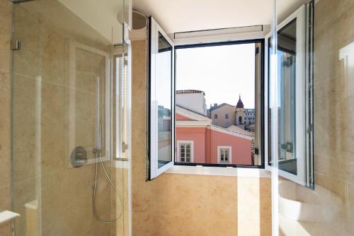 a bathroom with a shower and a large window at Pinia Penthouse by Corfuescapes in Corfu