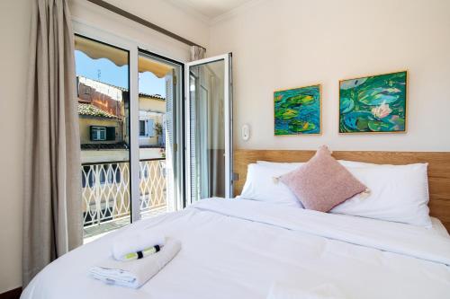 a bedroom with a bed and a large window at Pinia Penthouse by Corfuescapes in Corfu