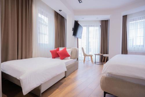 a hotel room with two beds with red pillows at Bazaar Inn Boutique & Luxury Rooms in Skopje