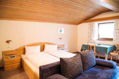 sypialnia z łóżkiem, kanapą i stołem w obiekcie Ferienhaus Nationalpark w mieście Neukirchen am Großvenediger