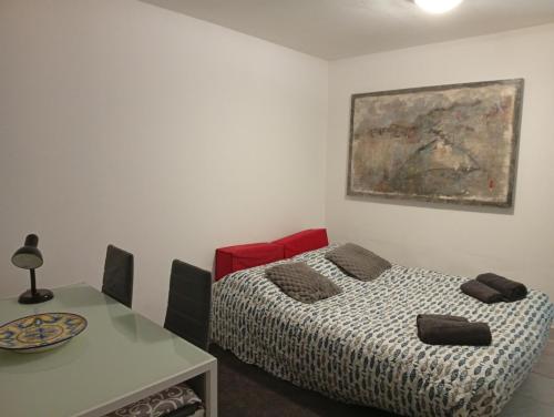 a room with a bed and a table and a painting at studio stella in Sospel
