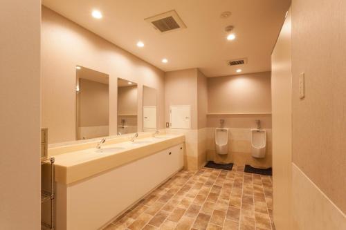 a large bathroom with two sinks and two urinals at HOTEL THE CUBE Naha Kokusai Street in Naha