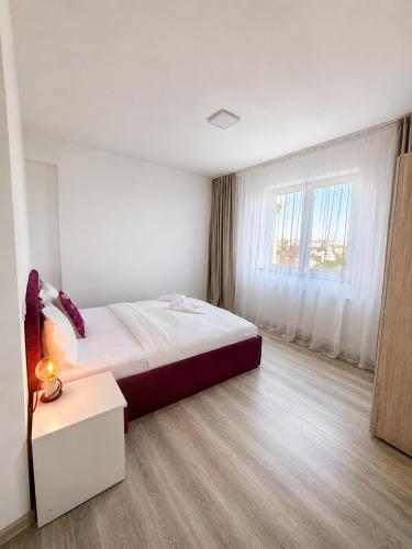 a white room with a bed and a window at Nolia Apartments in Bucharest