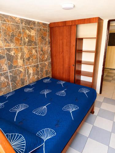 a bed in a room with a blue comforter at Apartamento FullLife in Zipaquirá