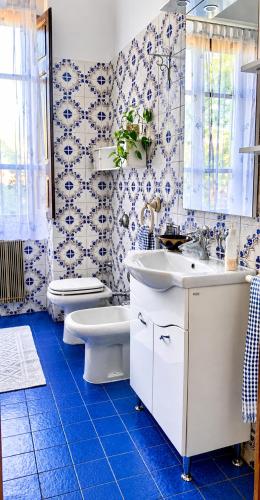 a blue and white bathroom with a toilet and sink at Guest House A Due Passi in Olbia