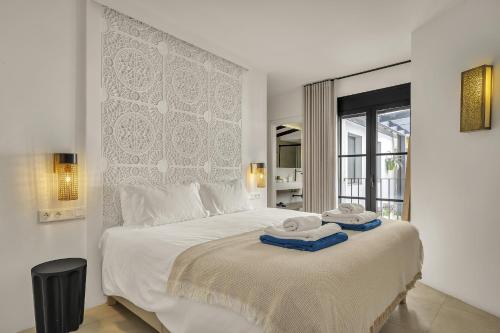 a bedroom with a large white bed with towels on it at Casa Azalia - Marbella Old Town by Finest Rentals in Marbella