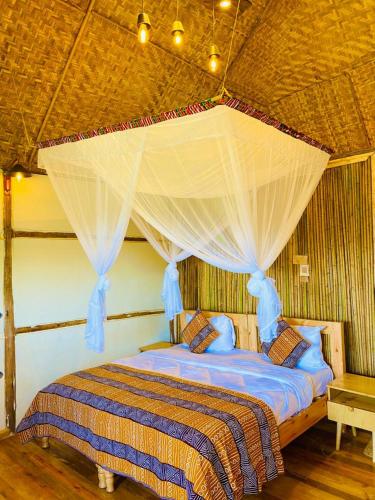 a bedroom with a bed with a mosquito net at Bwindi Coffee Lodge in Kachulagenyi