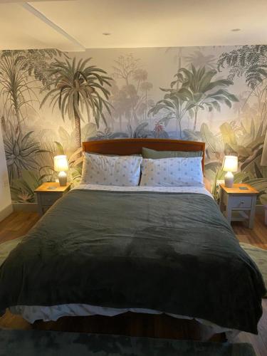 a bedroom with a large bed with plants on the wall at Castle cottage in Cowbridge