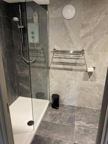 a shower with a glass door in a bathroom at Castle cottage in Cowbridge