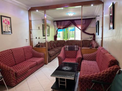 a living room with a couch and chairs and a table at Spacious Family Apartment - Air Conditioning, Pool & Garden Views in Martil