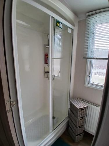a glass shower in a bathroom with a window at 8 Moray View Seton Sands in Port Seton