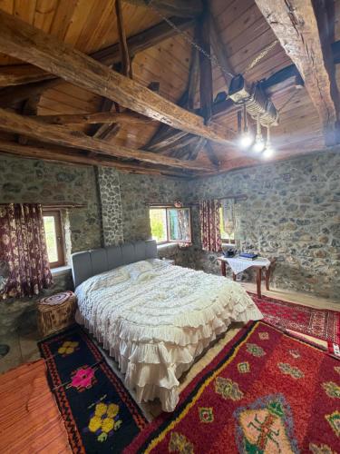 a bedroom with a large bed in a stone wall at Hasan Nika's Tower in Karicë