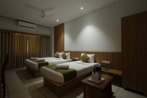 a hotel room with two beds and a table at Hotel Decent in Bhāndu