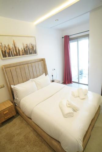 a bedroom with a large white bed with a window at Chic Moderne avec Touche Marocaine in Kenitra