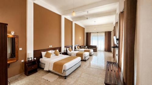 a hotel room with two beds and a television at Thuruliya Hotel in Ramboda