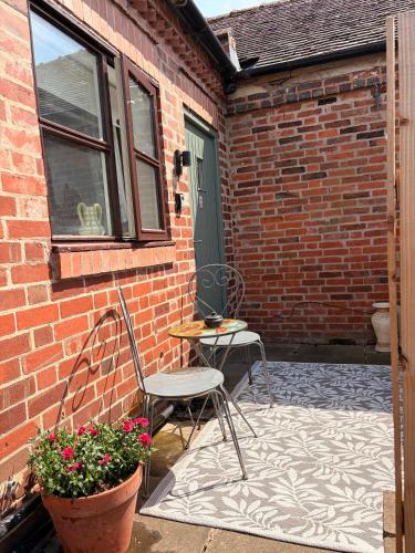 a patio with two chairs and a table and a window at The Bungalow in Lichfield